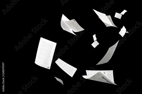 Photographie Many flying business documents isolated on black background