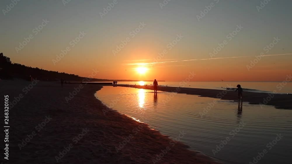 Beach sun people walk by sunset on the waves Beach sun people walk by sunset on the waves