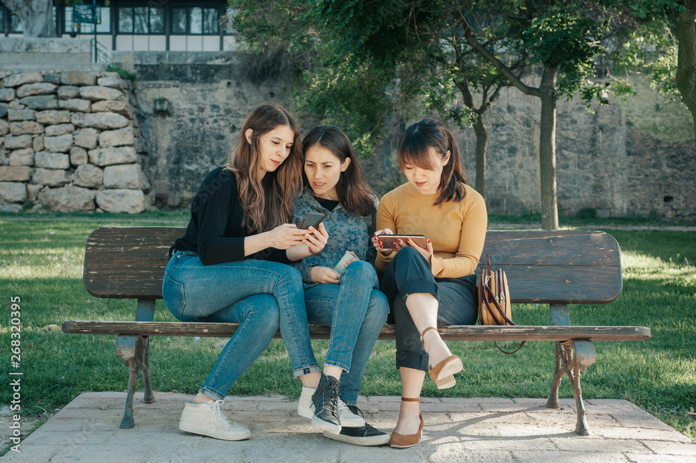 three friends with their mobile phones three friends with their mobile phones