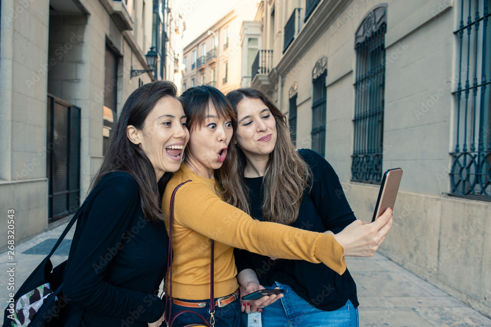 three friends making a selfie happy faces