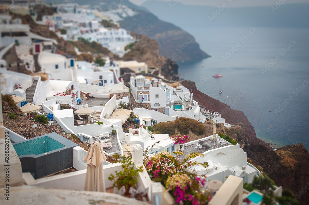 Tilt shift effect of houses and terraces of the village of Oia above a bay