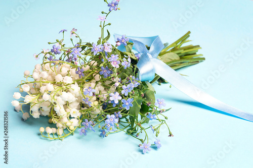 A bouquet of lily of the valley and forget-me-nots with a ribbon.