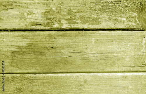 Weathered wooden painted wall in yellow tone.