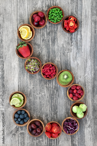 Super food concept for healthy eating with fruit and vegetables forming a letter s on rustic wood background. Foods high in antioxidants, anthocyanins, dietary fibre and vitamins.