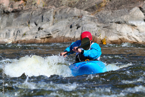 Fototapeta Naklejka Na Ścianę i Meble -  Whitewater kayaking on fast moving water of mountain river among the rapids, extreme water sport. Kayak freestyle on whitewater.