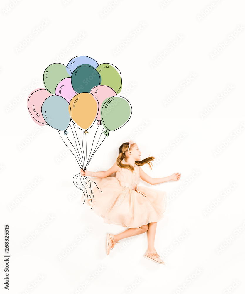 top view of cute kid in pink dress holding colorful balloons on white