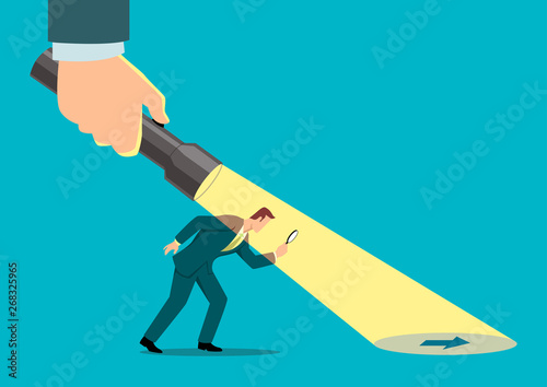 Businessman being guided by a hand holding a flashlight