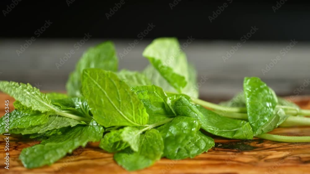 Super Slow Motion Shot of Fresh Mint Falling on Wooden Cutting Board at 1000fps. Super Slow Motion Shot of Fresh Mint Falling on Wooden Cutting Board at 1000fps.