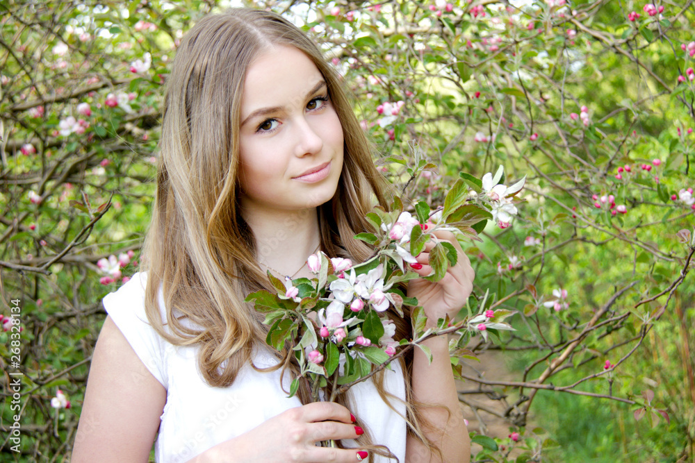 young caucasian woman with healthy skin and hairs stay in apple blossom garden young caucasian woman with healthy skin and hairs stay in apple blossom garden