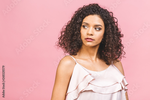 Beauty closeup portrait of young african american girl with afro. Girl isolated against pink background. Ideal skin.
