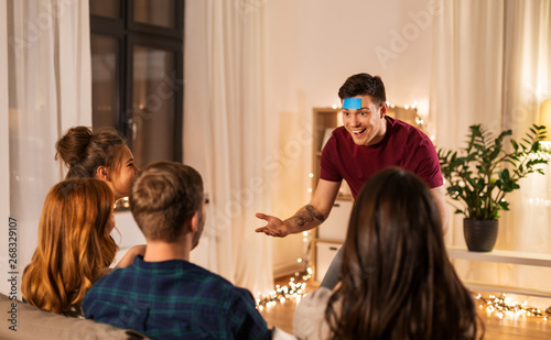 Billede på lærred friendship, leisure and entertainment concept - happy friends playing guessing g