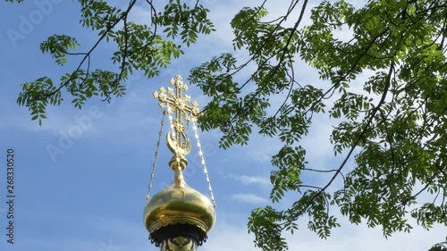 cross on a church against the sky and green trees. GOMEL, BELARUS