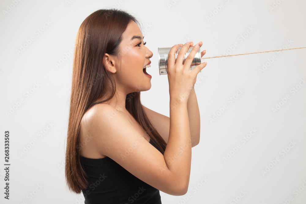 Young Asian woman shout with tin can phone. Young Asian woman shout with tin can phone.