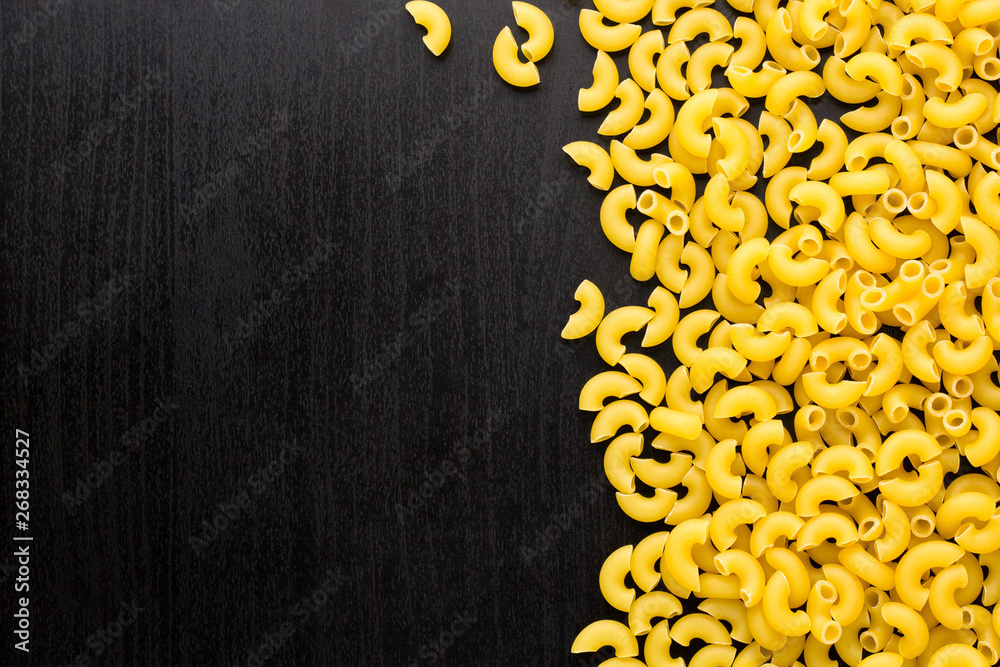 Border of A pile of pasta horns on black background with copyspace