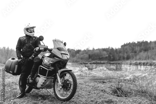 Motorcyclist man with Adventure Motorbike. Off road. Motorcycle trip. enduro Traveling  Lifestyle Travel dual sport outdoor concept. clothing with protection  black and white. biker helmet.