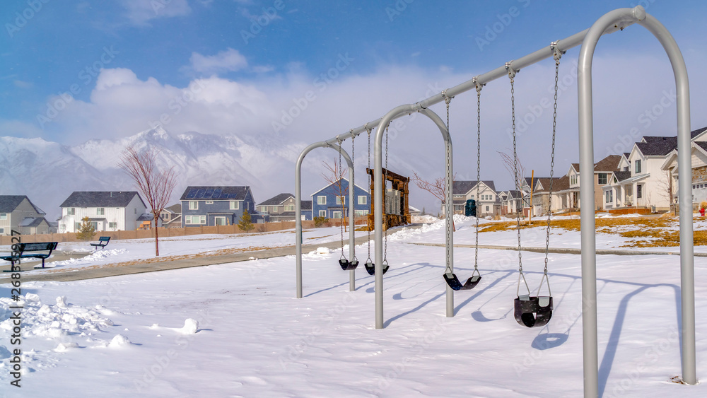 Clear Panorama Baby swings at a playground blanketed with clean snow on a sunny winter day Clear Panorama Baby swings at a playground blanketed with clean snow on a sunny winter day