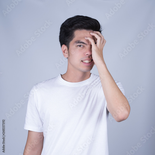 Portrait handsome young asian man wearing a white T-shirt stressed and anxiety isolated on grey background. Asian man people. business success concept.