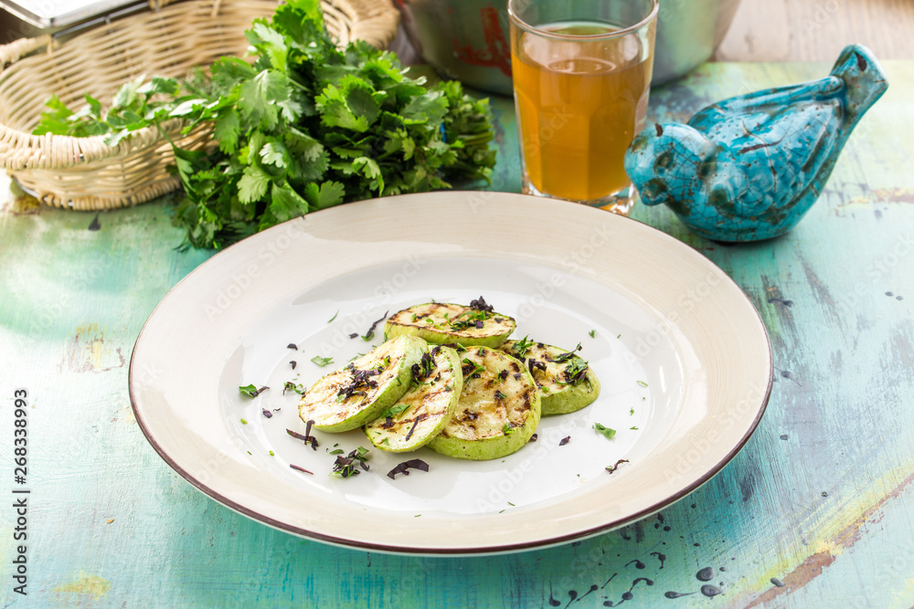 green zucchini grilled with dark stripes on blue wooden table green zucchini grilled with dark stripes on blue wooden table