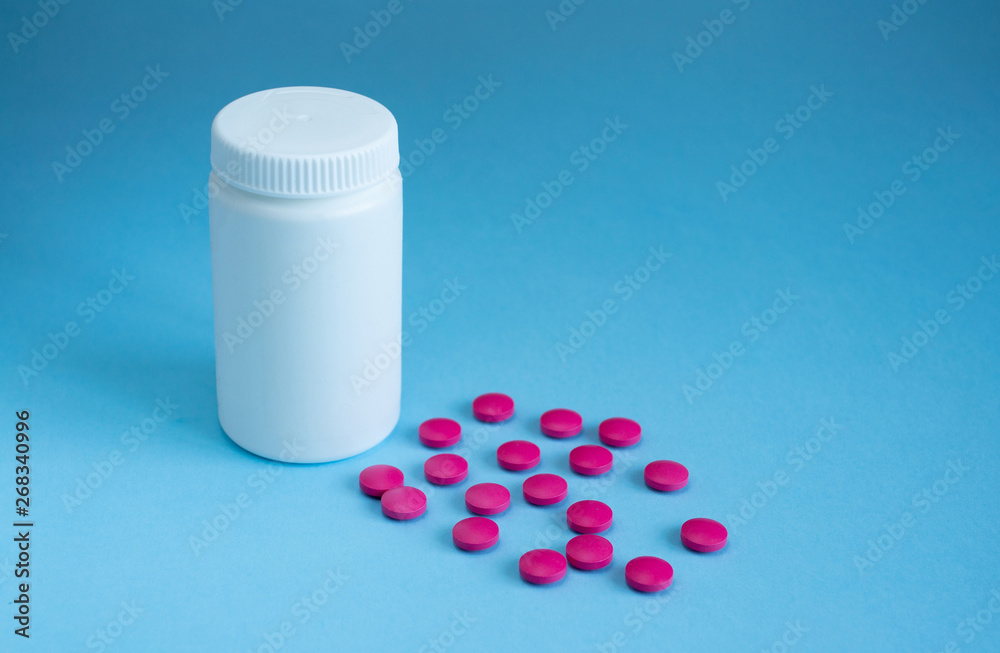 Tablets and closed bottle on a blue background. Concept medicine, pharmacology Tablets and closed bottle on a blue background. Concept medicine, pharmacology