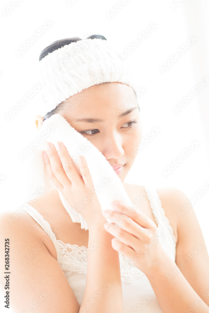 タオルで顔を拭く女性 タオルで顔を拭く女性