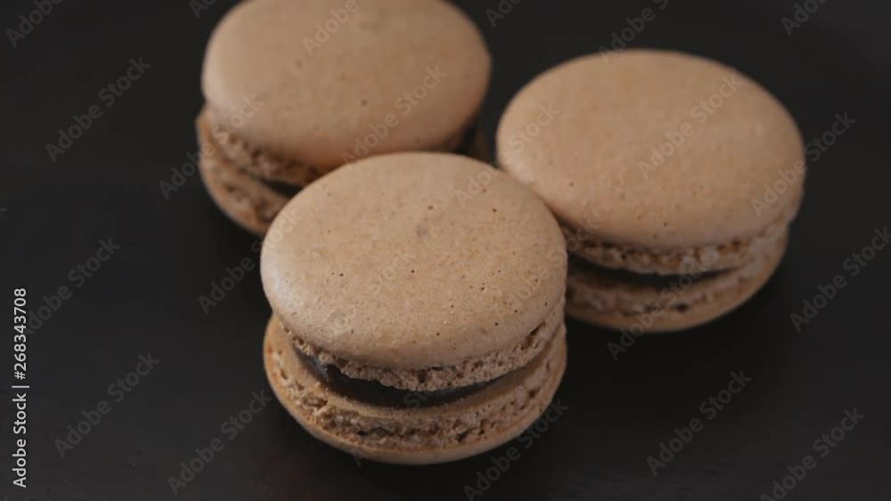 Beige macaroons on a dark plate Beige macaroons on a dark plate
