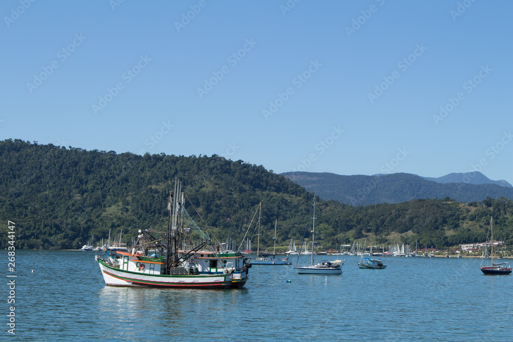 Beautiful landscape with ocean, boats and montains and blue sky.