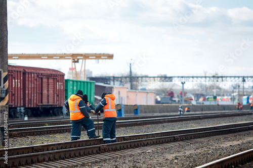 Fototapeta Naklejka Na Ścianę i Meble -  Employees of railway depot inspect repair and maintenance of railway rails in order to detect breakdowns and ensure safety of trains on railway movement with copy space