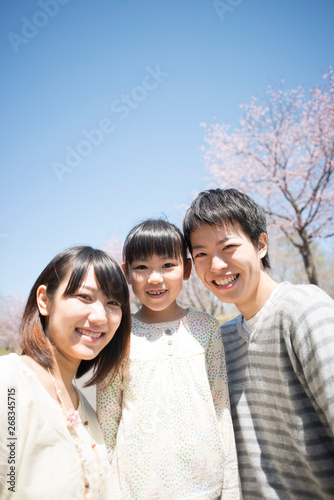 桜の前で微笑む親子