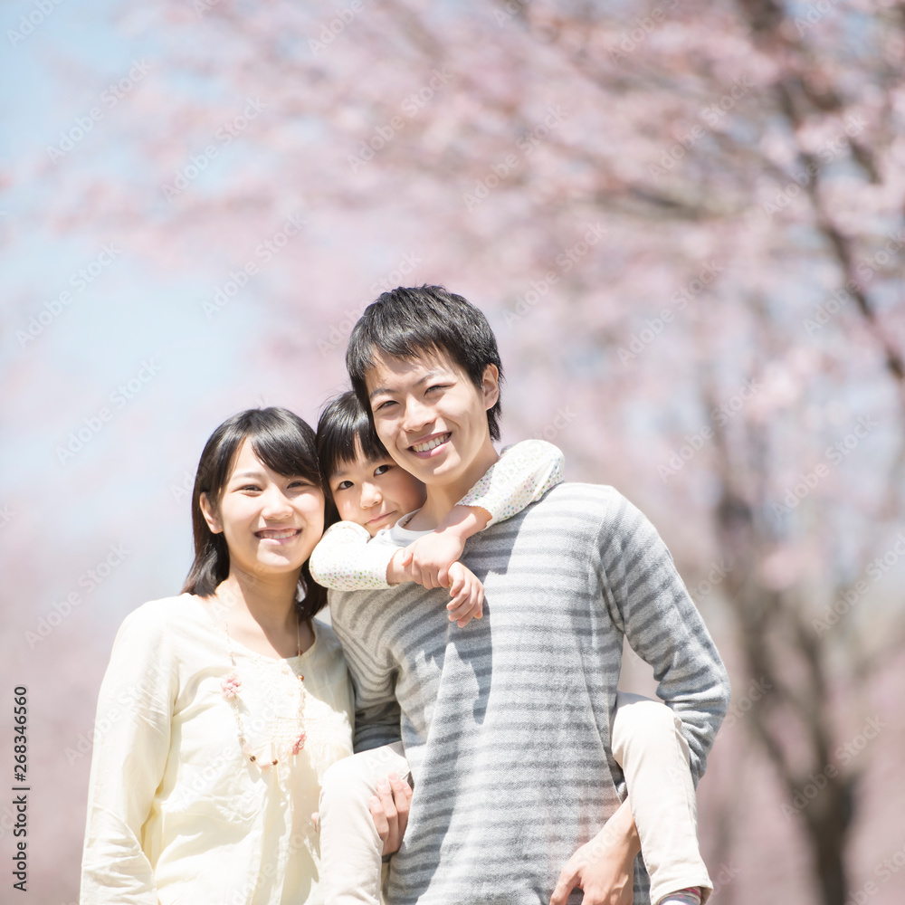 桜の前でおんぶをする親子 桜の前でおんぶをする親子