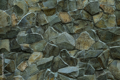 Stonework texture. Green grey stone wall background. Masonry of decorative tile. Abstract pattern of gray rocks wall. Texture of old stone wall. Dark granites facade of building. Grunge rock texture.