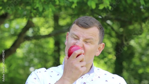 man wildly funny and quickly bites and eats an apple