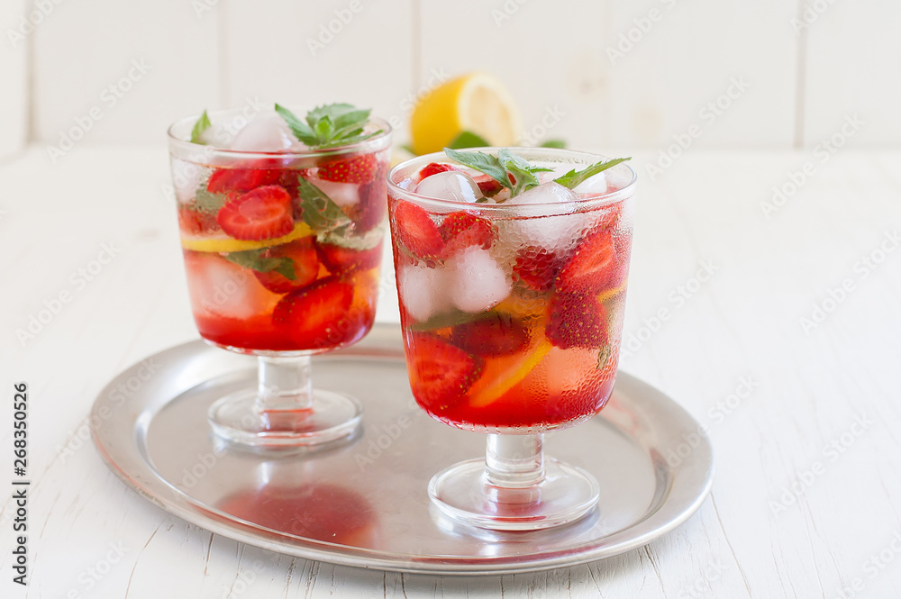Summer cold drink . Lemonade with mint and strawberries on a light background.
Summer cold drink . Lemonade with mint and strawberries on a light background.