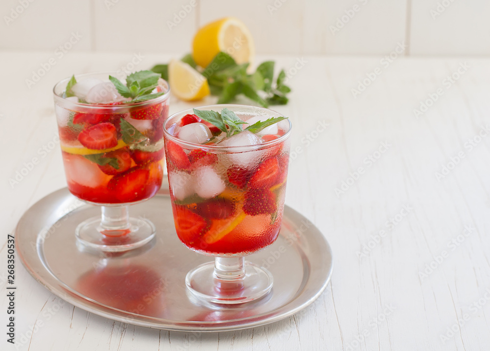 
Summer cold drink . Lemonade with mint and strawberries on a light background.
