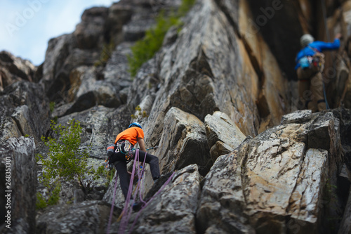 Two climbers climb up the rocks. Tilt-Shift effect. photo