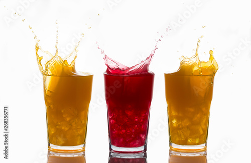 Concept of unique and one of a kind represented with splashes on glasses of orange juice and strawberry juice