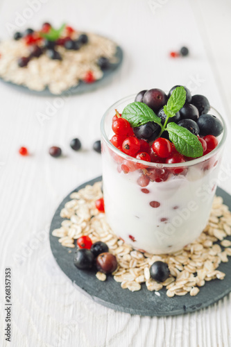 Healthy homemade greek yogurt with ribes, blueberries, oatmeal and mint
