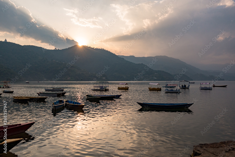 Sunset at Pokhara lake with boats and clouds in background