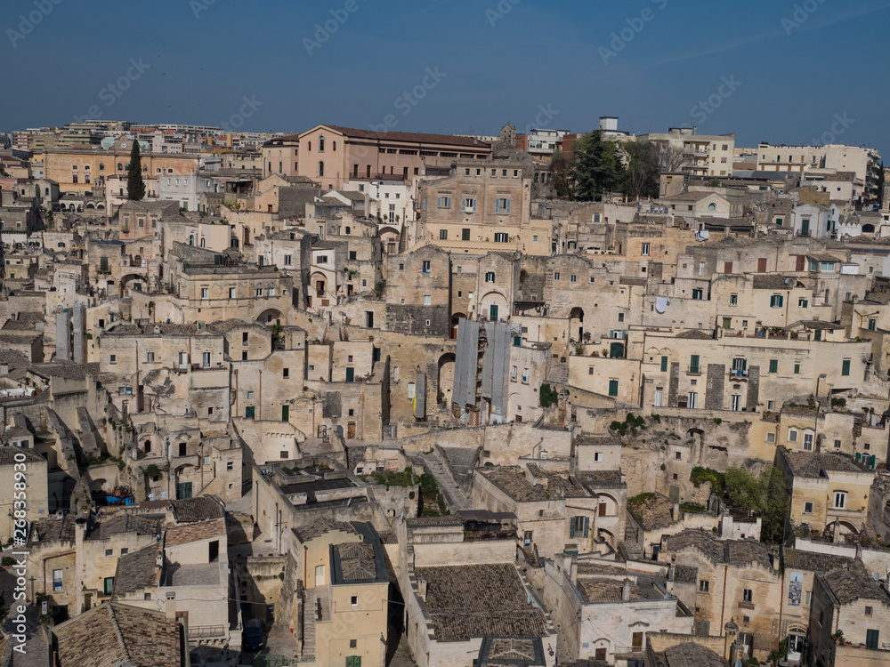 Panoramic view of typical stone houses of Sassi di Matera and church under blue sky with clouds, capital of europe culture 2019. April, 2019