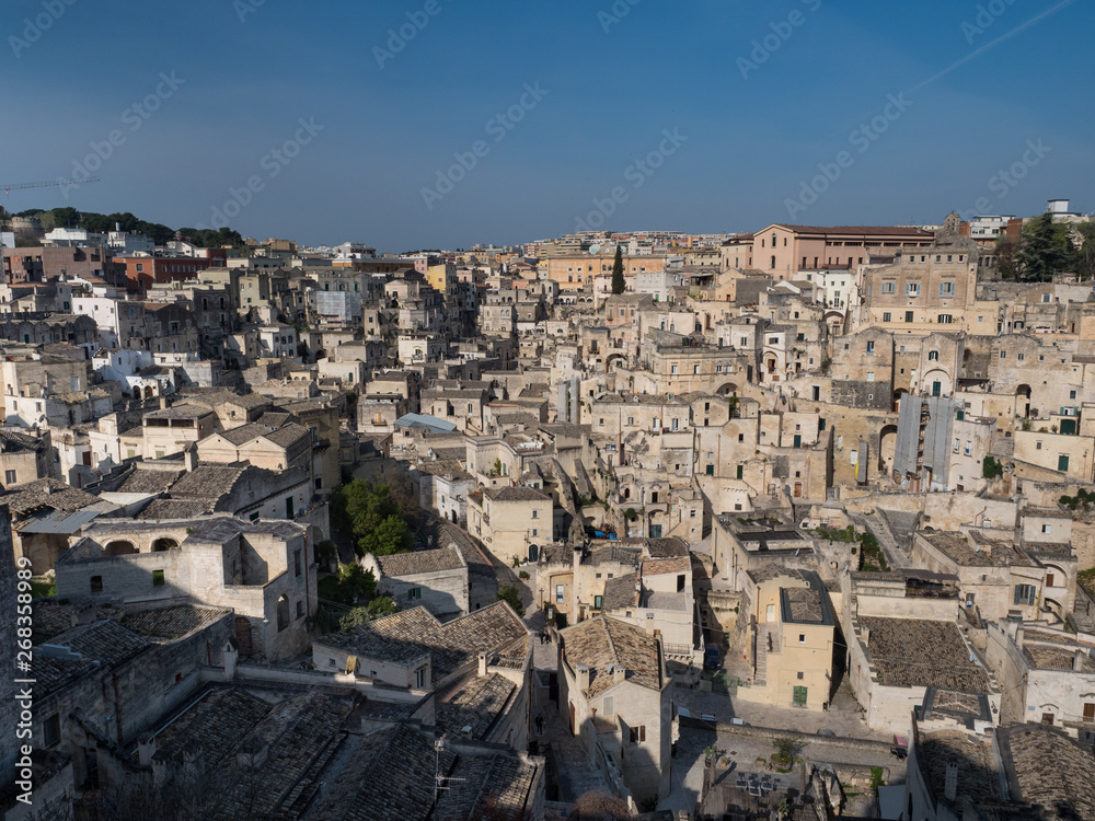 Panoramic view of typical stone houses of Sassi di Matera and church under blue sky with clouds, capital of europe culture 2019. April, 2019