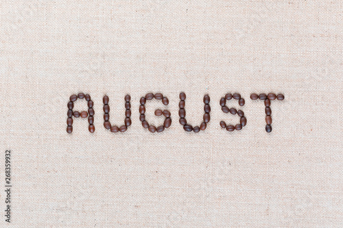 The word August written with coffee beans shot from above, aligned in the center, closeup.