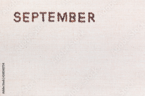 The word September written with coffee beans shot from above, aligned at the top left.