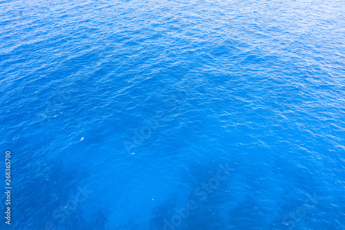 Blue sea water with small waves and color gradient texture background.