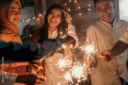 happiness lighting the takbir night fireworks with friends while celebrating the Eid holiday photo