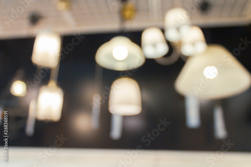 Light fixtures and bulbs in blurred shot at home department store. Abstract hangings on wall.