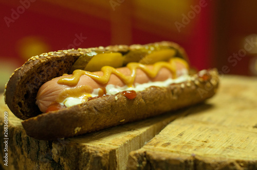 hot dog sandwich with sausage on a wooden board