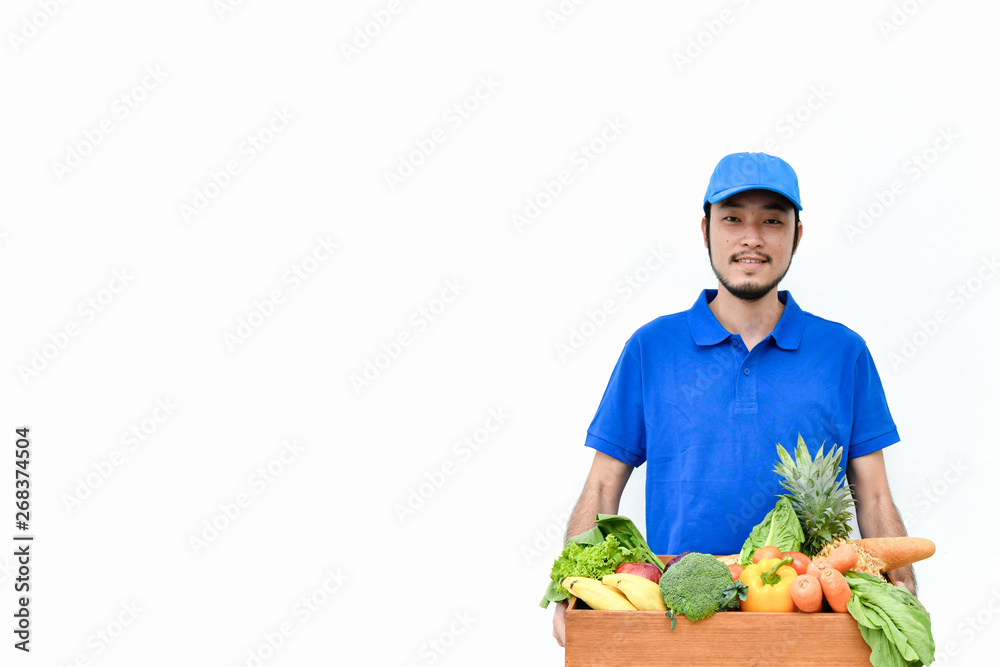 Delivery concept. Delivery guy holding a bag of groceries isolated on white background. Delivery concept. Delivery guy holding a bag of groceries isolated on white background.