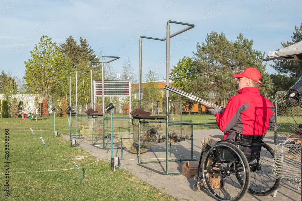 paralyzed man in a wheelchair is training in skeet shooting, hunter in a wheelchair paralyzed man in a wheelchair is training in skeet shooting, hunter in a wheelchair