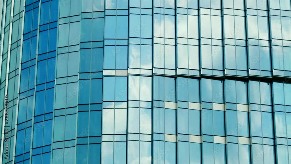 Time lapse of clouds reflecting onto the glass of a large office building. Modern Business Office Buildings with Glass Reflection. Reflection of clouds in a modern skyscraper. Time lapse of clouds reflecting onto the glass of a large office building. Modern Business Office Buildings with Glass Reflection. Reflection of clouds in a modern skyscraper.