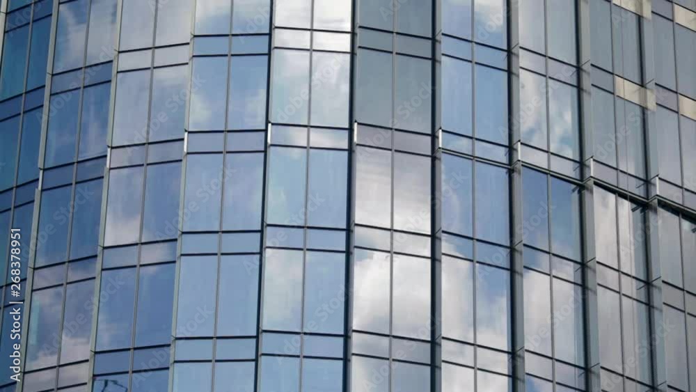 Time lapse of clouds reflecting onto the glass of a large office building. Modern Business Office Buildings with Glass Reflection. Reflection of clouds in a modern skyscraper. Time lapse of clouds reflecting onto the glass of a large office building. Modern Business Office Buildings with Glass Reflection. Reflection of clouds in a modern skyscraper.