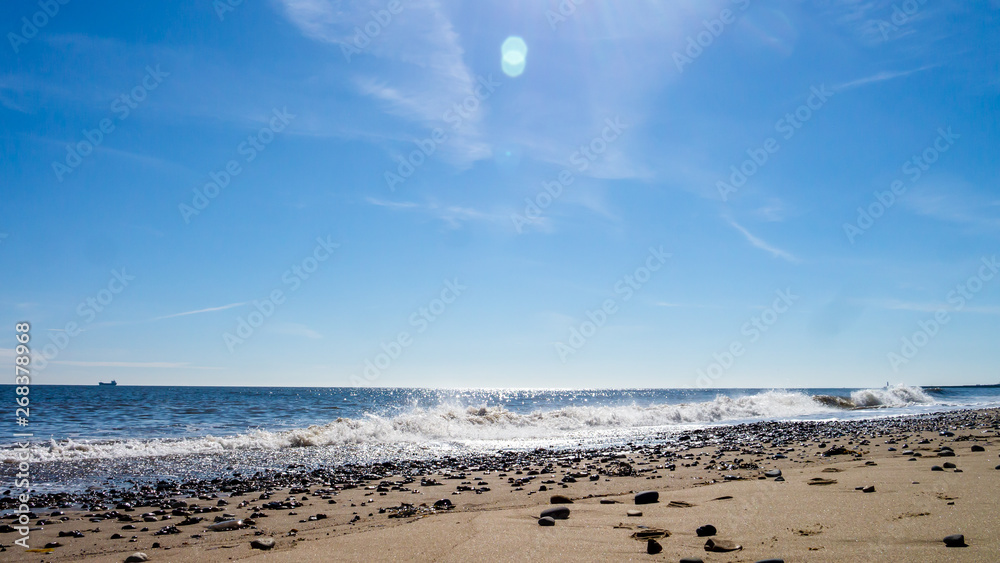Seaham Hall Beach in County Durham, England UK.  Image taken on a beautiful warm sunny day with the tide coming in and covering the pebble strewn golden sands.